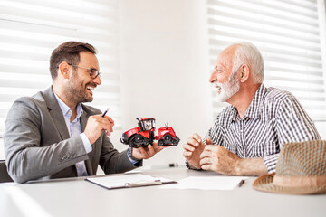 Farmer at tractor dealership buying new agricultural machine for agribusiness.