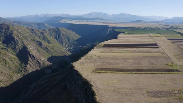 Forward reveal aerial shot of plateau over Debed river gorge on sunny summer day. Odzun, Lori Province, Armenia.
