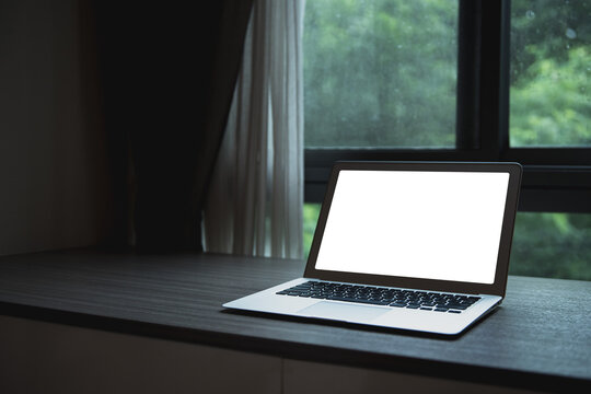 Laptop With Blank Screen On Wood Table With Natural View Of Big Tree Out Of Window. Home Interior Or Office Background.