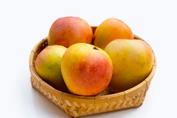 Mango in bamboo basket on white background. Tropical fruit