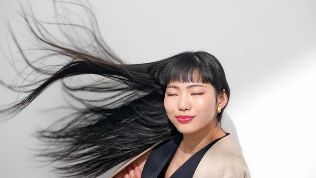 ロングヘアを風になびかせる女性　ヘアケアイメージ