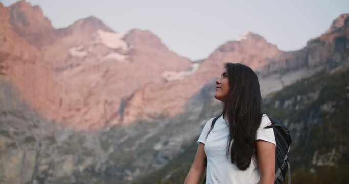Young woman hiker enjoying the view of the Swiss alps at sunset