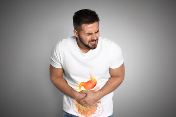 Healthcare service and treatment. Man suffering from abdominal pain on grey background....