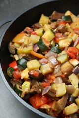 Delicious ratatouille in baking dish on grey table, closeup