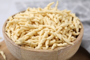 Uncooked trofie pasta in bowl on table, closeup