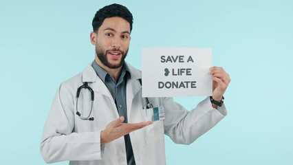 Donate, poster and man doctor with medical request as professional volunteer isolated in a studio blue background. Pointing, placard and healthcare employee ask for help in charity with sign