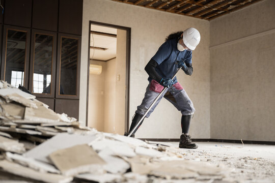 Professional craftsmen on site, such as demolition companies breaking ceilings and exterior walls of detached houses Wide angle