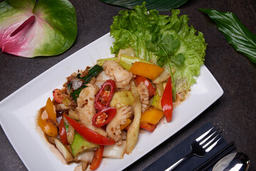 Stir-fried beef, garlic and celery. Asian dish composition on a dark table