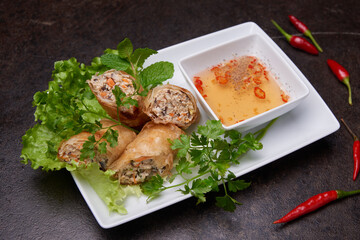 Springrolls on a dark table top view. Pan-asian dish cuisine