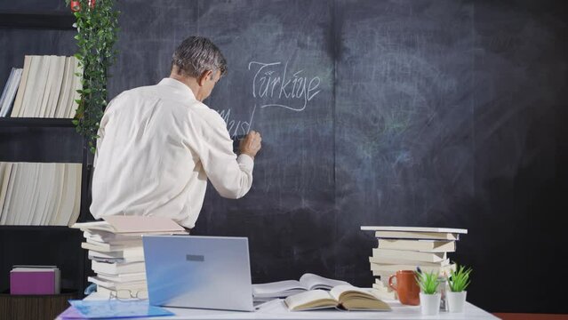 The historian man writing Mustafa Kemal Atat&uuml;rk on the blackboard.