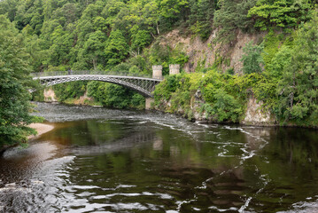 Craigellachie Bridge over the River Spey, Moray, Scotland,United Kingdom. Made of cast iron, designed by Thomas Telford and built between 1812 and 1814. - obrazy, fototapety, plakaty