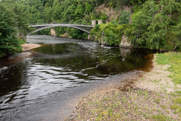 Fototapeta na wymiar Craigellachie Bridge over the River Spey, Moray, Scotland,United Kingdom. Made of cast iron, designed by Thomas Telford and built between 1812 and 1814.