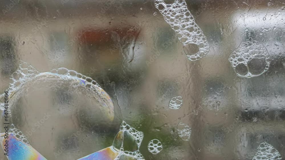 Poster lots of sticky multicolored soap bubbles on the surface of a wet rainy window. blowing soap rainbow 