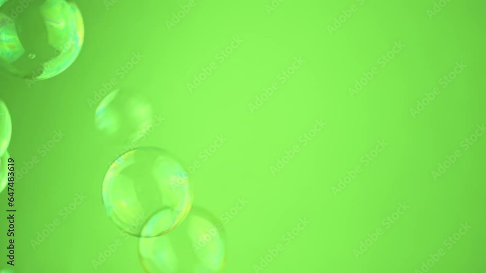 Poster close up, lot soap bubbles float on a green background in empty space. molecules. chaotic movement. 