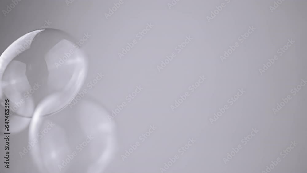 Poster Group Soap Bubbles Moving on a Gray Background in Empty Space. Close up. Blowing large, small transparent water spheres. Abstract. Blurred motion, focus. Isolated. Chroma key. Monochrome. Slow motion.