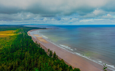 Scenic aerial view of an endless, deserted beach on a cloudy summer day on beautiful Haida Gwaii, BC.