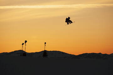 Silhouette Of A Snowboarder Jump In Mid-Air At Sunset; Norway