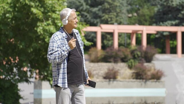 Cheerful man listening to music outdoors.