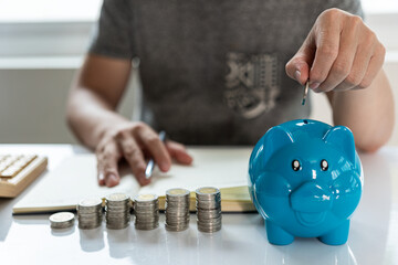 Young man and pile of coins to plan increasing savings strategy with pile of coins for future...