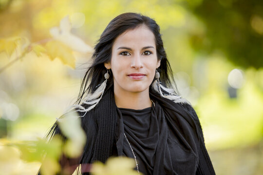 A Young Aboriginal Female Model Looks At The Camera In A Shoulders Up Headshot Taken In The Outdoors In Autumn; Vancouver, British Columbia, Canada