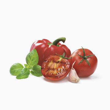 Roasted Tomato With Garlic, Red Bell Pepper And Basil Leaves On A White Background; Toronto, Ontario, Canada