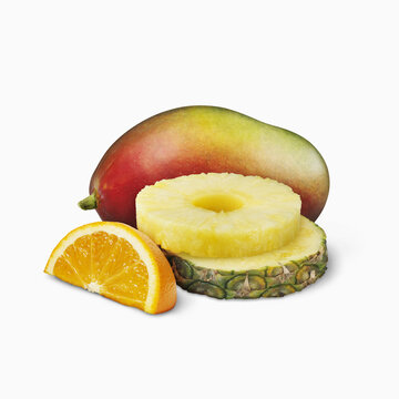 Mango, Pineapple Slices And Orange Wedge On A White Background; Toronto, Ontario, Canada