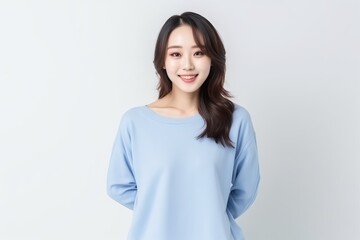 Portrait of an Asian woman with white wall background.