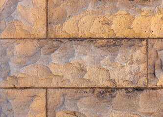 A close-up view of natural stones and bricks used for facing buildings and houses.