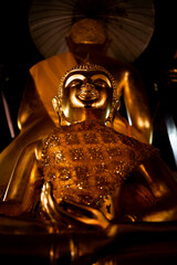 small Buddha statue placed behind a large Buddha statue in the temple.