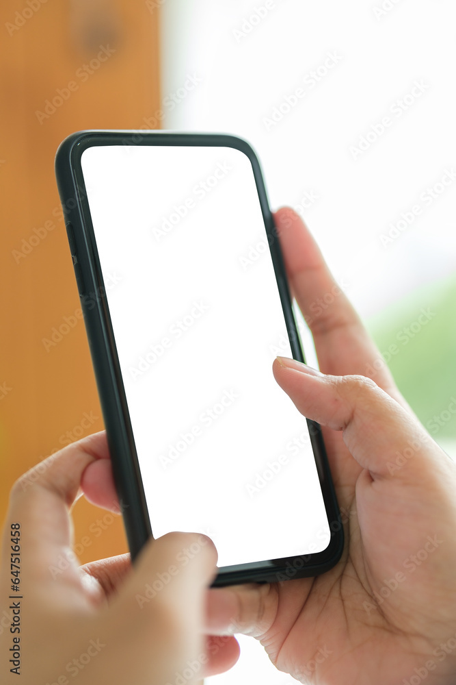 Poster Closeup view of hands holding smartphone with blank screen and left side with empty space for your advertise or text message.