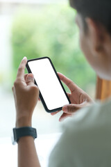 View over shoulder of man hands holding smart phone. Empty screen for your advertise text.