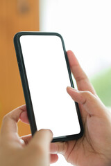 Closeup view of hands holding smartphone with blank screen and left side with empty space for your advertise or text message.