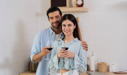 Happy couple holding wine glasses touching foreheads enjoying a tender moment, romantic date...
