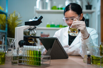 Asian woman scientist plant science laboratory research, biological chemistry test, green nature organic leaf experiment in test tube.