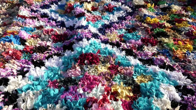 Colorful handmade, traditional, Moroccan carpet, rug, made with fabric and cloth waste material. Concept of upcycling useless material. Abstract pattern background 4k footage.