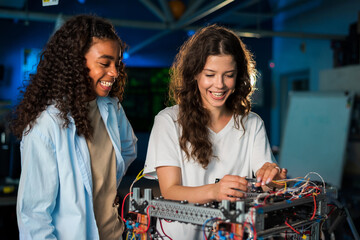 Two young women doing experiments in robotics in a laboratory