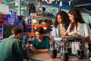 Group of young people doing experiments in robotics in a laboratory - Powered by Adobe