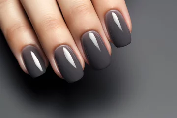  Closeup woman hand with dark gray and black nail polish on fingernails. Nail manicure with gel polish at luxury beauty salon. French manicure. Nail art and design. Female hand model. © Artinun