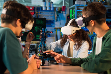 Group of young people in VR glasses doing experiments in robotics in a laboratory. Robot on the...