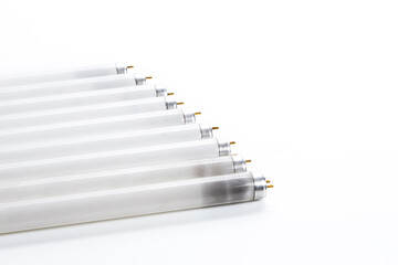 Energy Saving Concepts. Line of Used Obsolete Fluorescence Lamps Placed on Pure White Background.