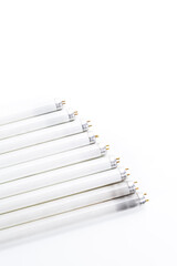 Energy Saving Concepts. Line of Used Obsolete Fluorescence Lamps Placed on Pure White.