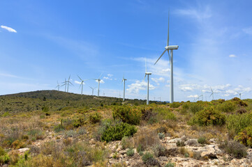 Fototapeta na wymiar Wind turbine in mountains. Eolic park windpower. Wind farm or New Wind green energy. Wind turbines alternative energy. Windmill power clean electricity generation in Viver, Castellón, Caudiel, Spain