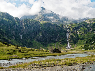 Sulzenaufall waterfall in the Stubai Alps in Austria. A green valley, rocky mountains and a powerful waterfall