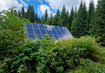 self-sufficient cottage house in the forest thanks to solar panels covering the roof in the...