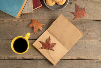 dried autumn leaves and paper with copy space on wooden table
