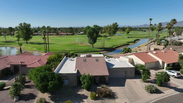 High end homes in country club golf course in southwest USA. Aerial rising shot revealing greens on prestigious course.