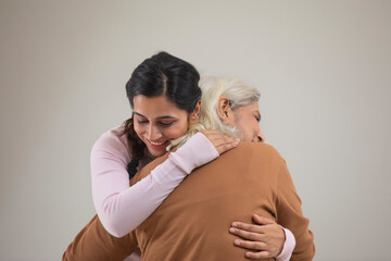 Fototapeta premium PORTRAIT OF A YOUNG WOMAN HUGGING A SENIOR WOMAN