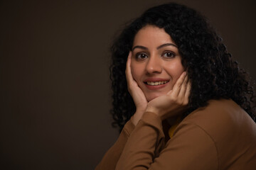 Fototapeta premium Close-up portrait of a woman with hands on cheek looking at camera