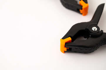 A close-up of a orange and black studio clips on a white background.