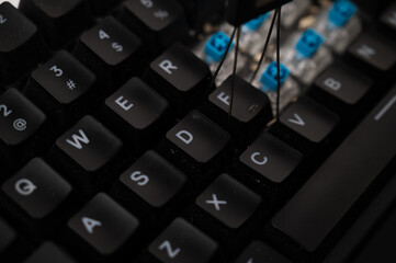 Close-up of a cleaning in progress of a mechanical keyboard with blue switched, full of debris.